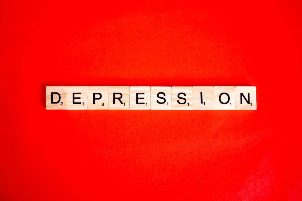 Scrabble tiles spelling out 'Depression' on a bright red background.