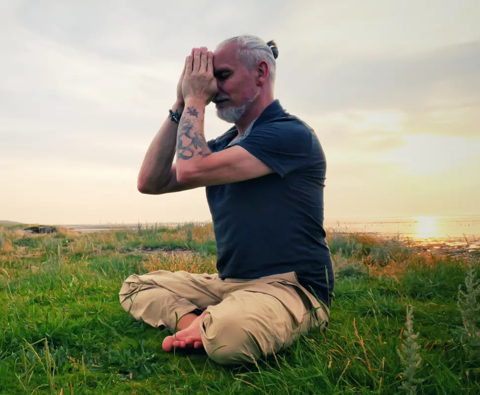 Breathwork Instructor practicing breathing techniques and meditation outdoors at sunset, deep breathing for relaxation and mindfulness.